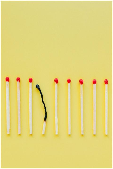 A line of matchsticks with one burned out symboliz