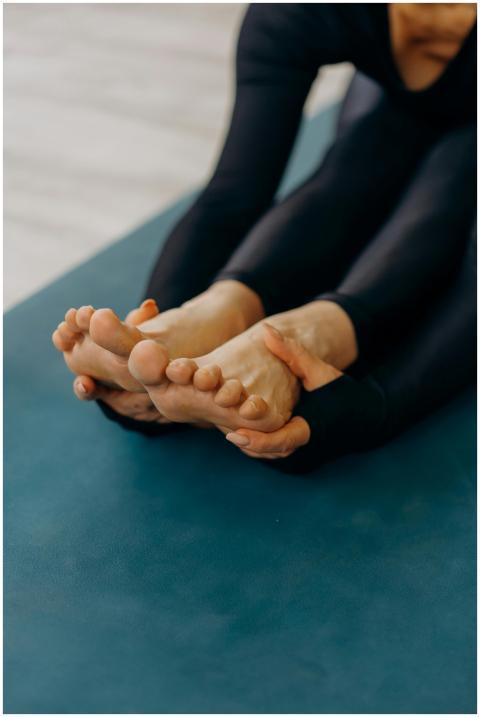 Person in a yoga pose stretching on a blue mat ind