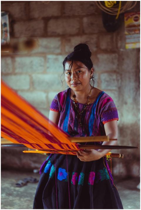 Indigenous Mexican woman weaving colorful fabric o