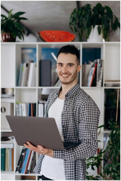 Young man in a casual checkered shirt holding a la