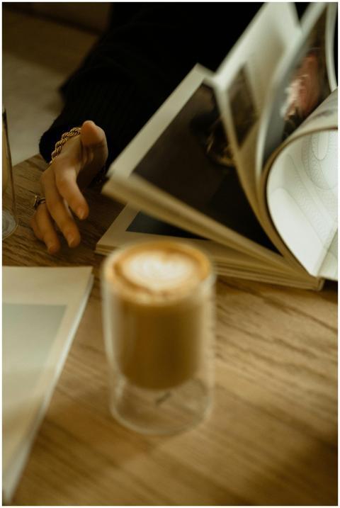A person enjoys a coffee while flipping through a