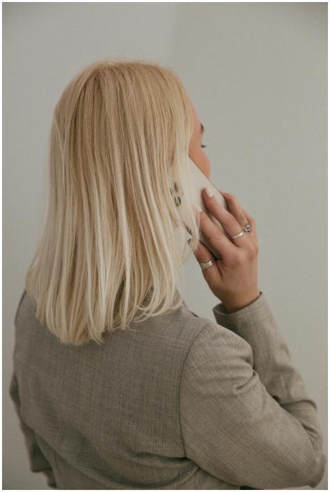 Back view of a blonde woman in a business suit tal