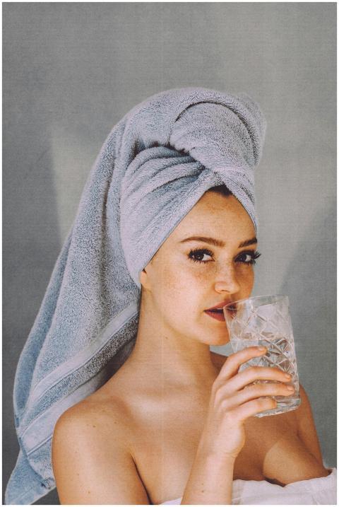 Young woman with hair wrapped with towel and bared