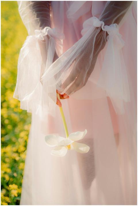 A delicate woman in a pink dress gracefully holdin