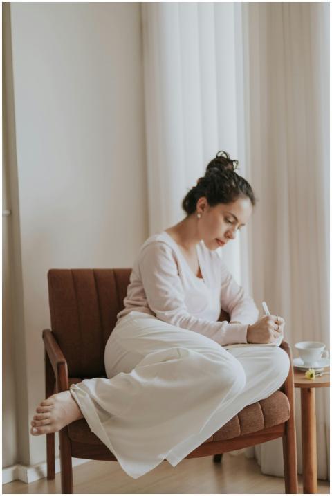 Young woman writing in a journal while relaxing at