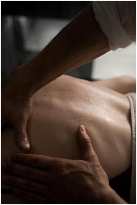 Close-up of hands performing a soothing back massa