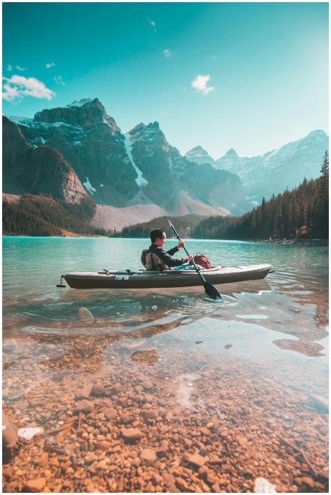 A lone kayaker paddles on the serene waters of Mor
