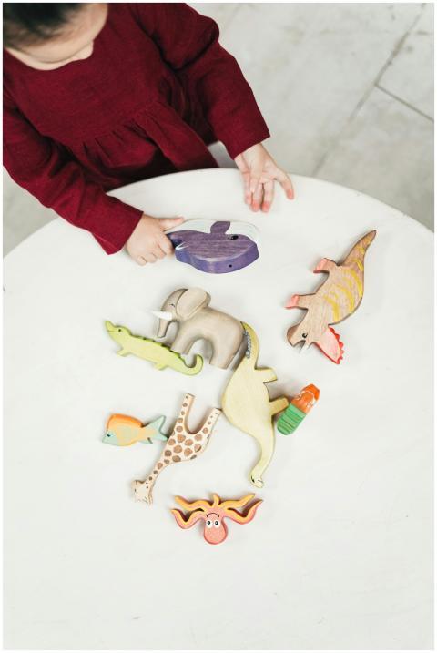 Young girl in red dress playing with assorted wood
