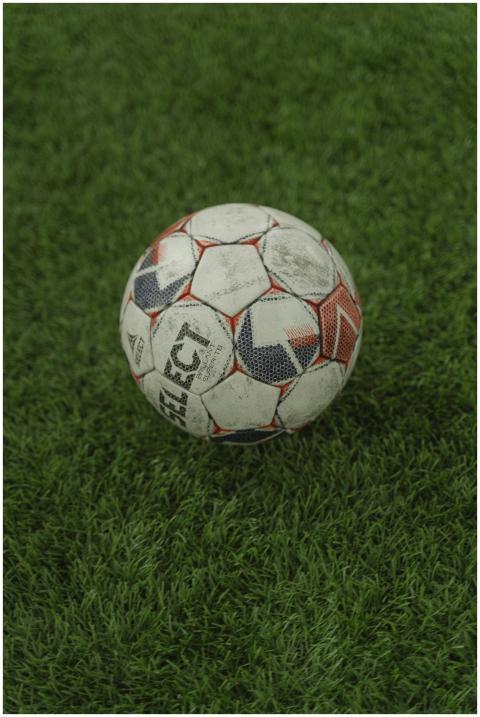 A detailed vertical shot of a weathered soccer bal