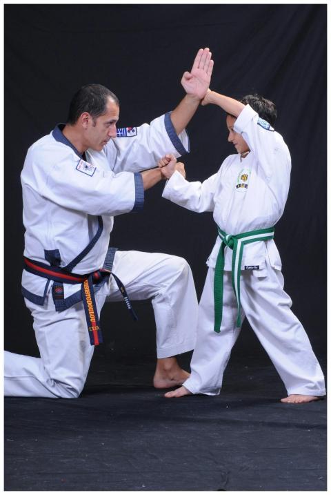 An instructor and child practicing martial arts te