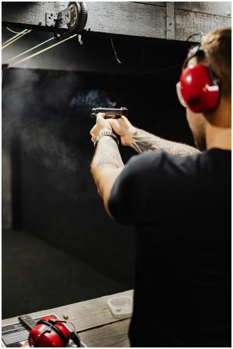 A man wearing ear protection shooting a handgun at