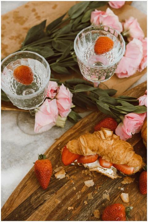 Flat lay of a picnic setup with croissants, strawb