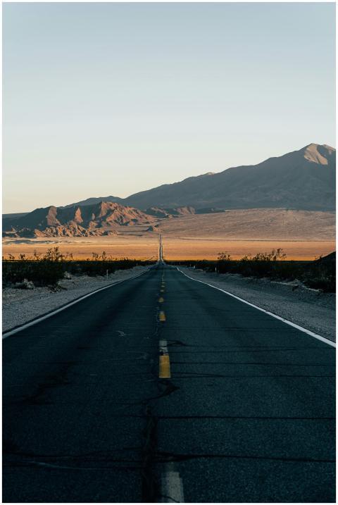 A long, empty highway stretches through the desert