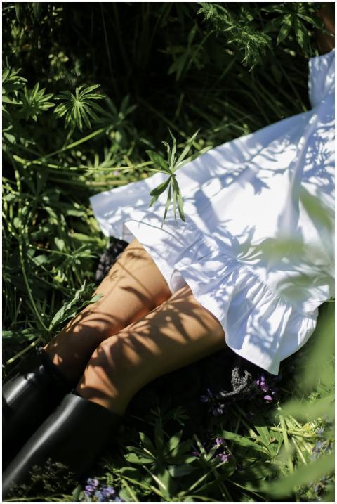 A woman in a white dress enjoying nature surrounde