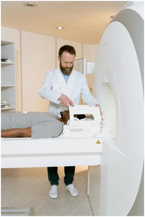 A doctor operates an MRI scanner for a patient exa