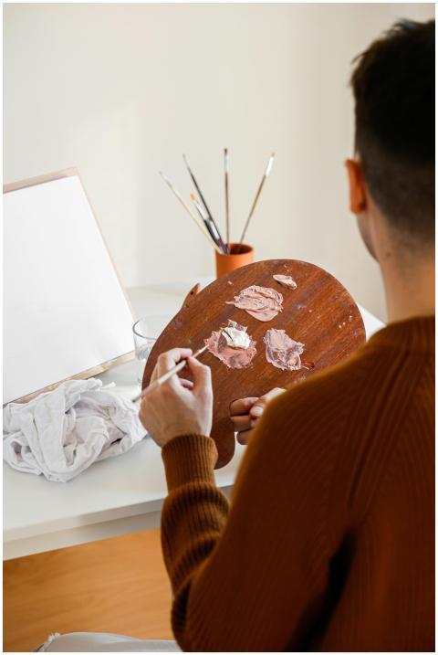 Artist using a palette to mix colors in a bright s