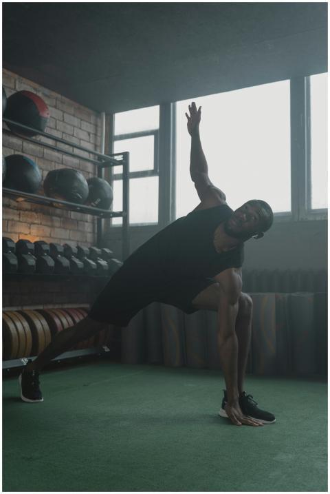 An athletic man performs a stretching exercise in