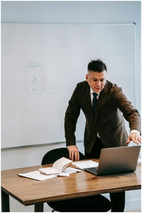 A professional man in a suit teaching online from