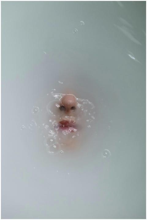 An artistic underwater portrait of a face emerging