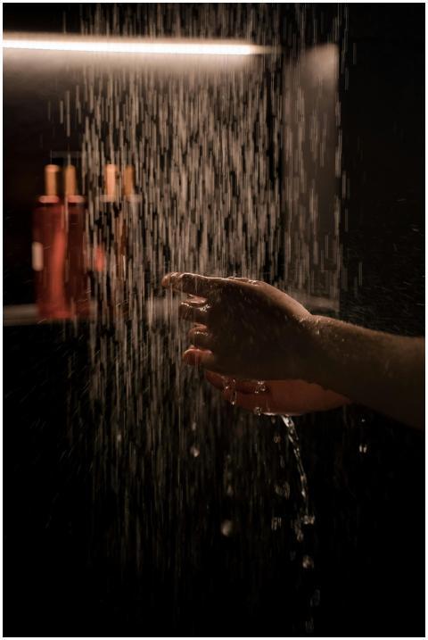 A tranquil hand under running water in a dimly lit