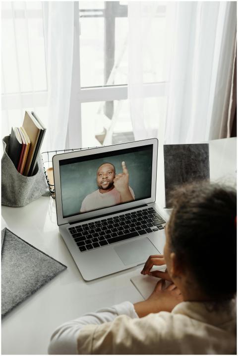 Young girl attending virtual class from home durin