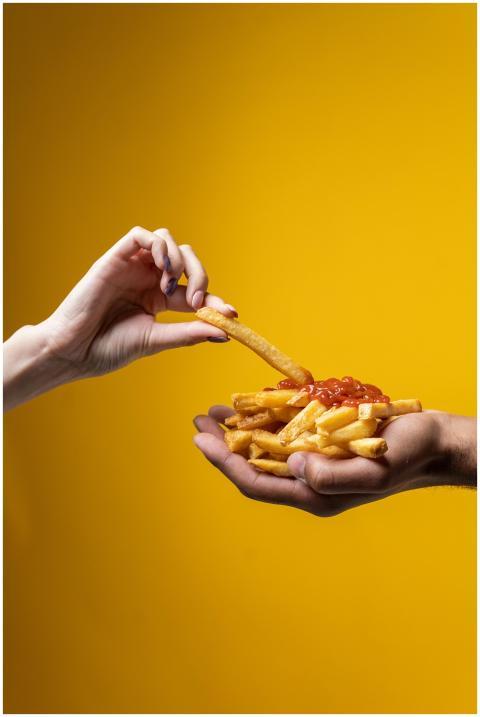 A close-up of hands sharing a delicious pile of fr