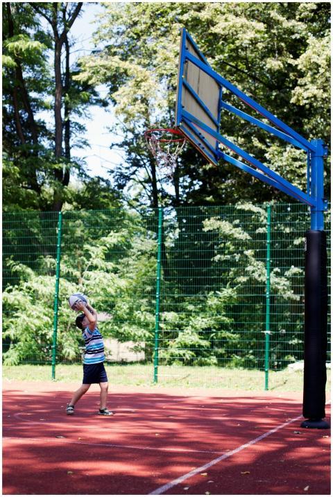 A child playing basketball on an outdoor court sur