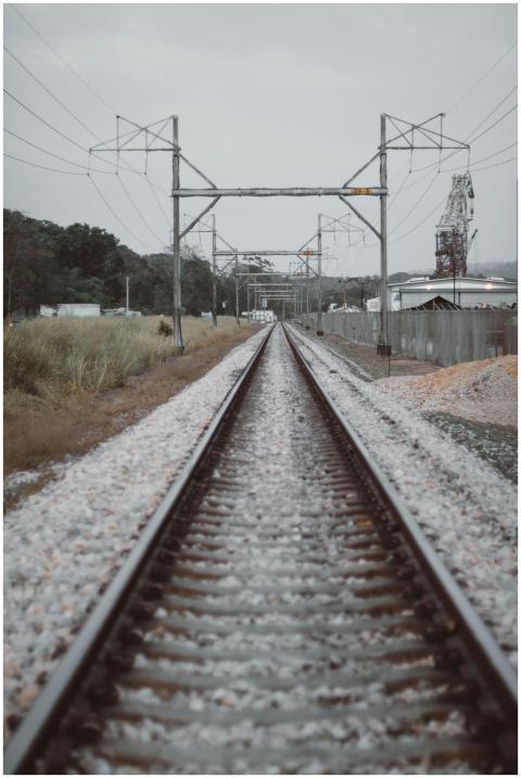 Long railway tracks surrounded by nature, showcasi