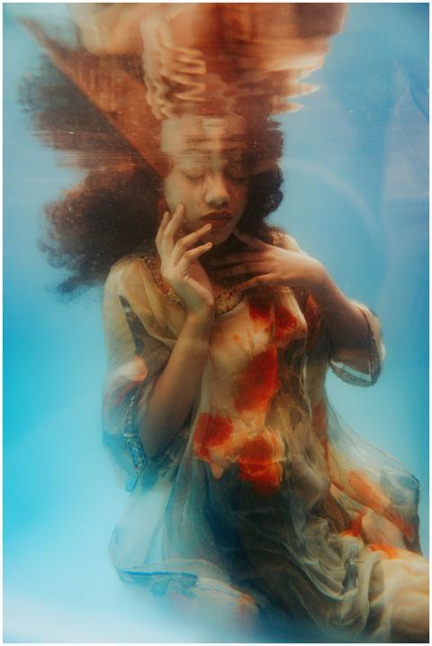 Artistic underwater photo of woman in floral dress
