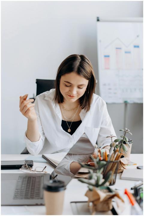 A young woman in a white dress shirt working at a