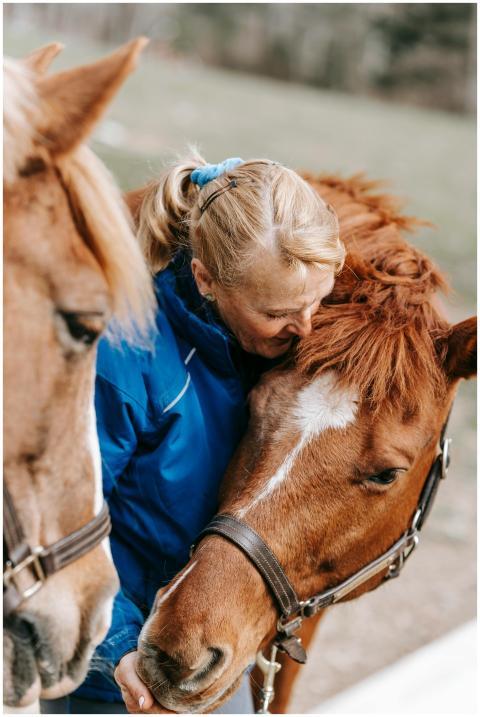 A woman lovingly embraces horses outdoors, showcas
