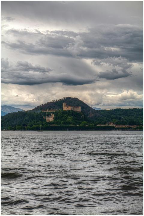 A dramatic landscape with a castle on a hill, fram