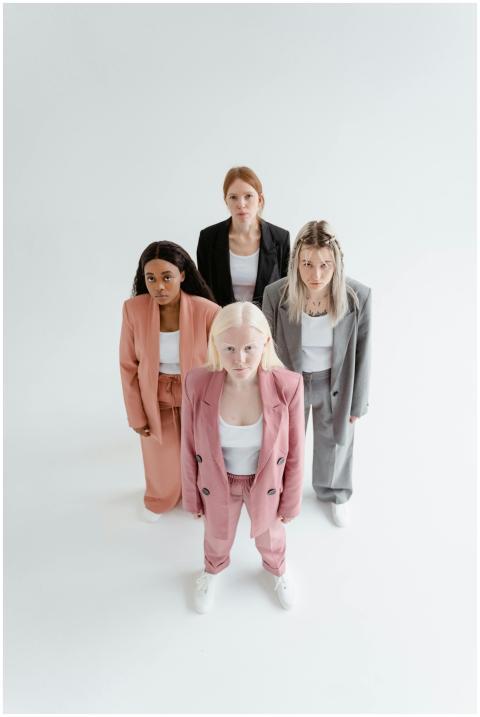 Four diverse women in modern suits, standing confi