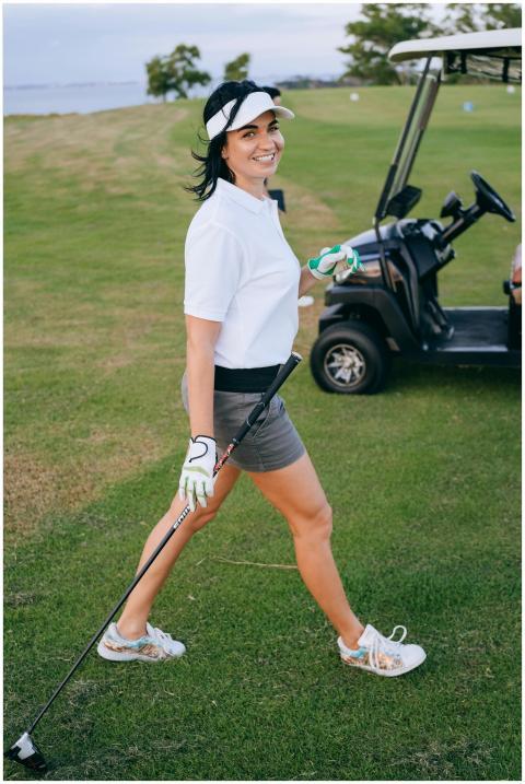A cheerful woman golfer walking on a scenic golf c