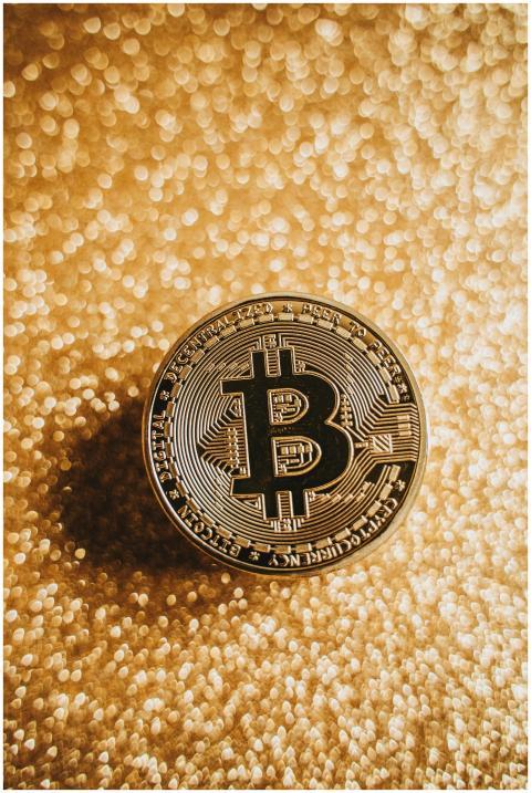 A close-up of a Bitcoin coin against a shimmering