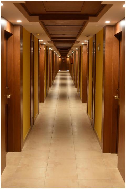 Long hallway view of a modern hotel with wooden do