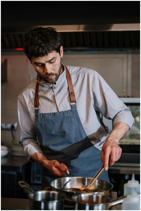 Chef in a blue apron focused on preparing food in