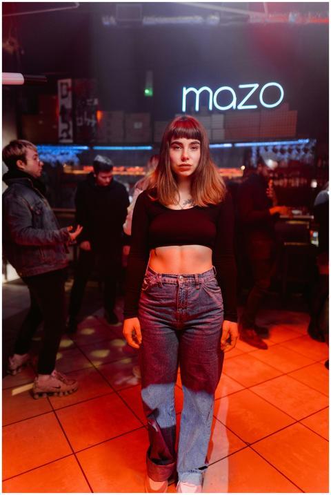 Fashionable young woman in denim and crop top stan