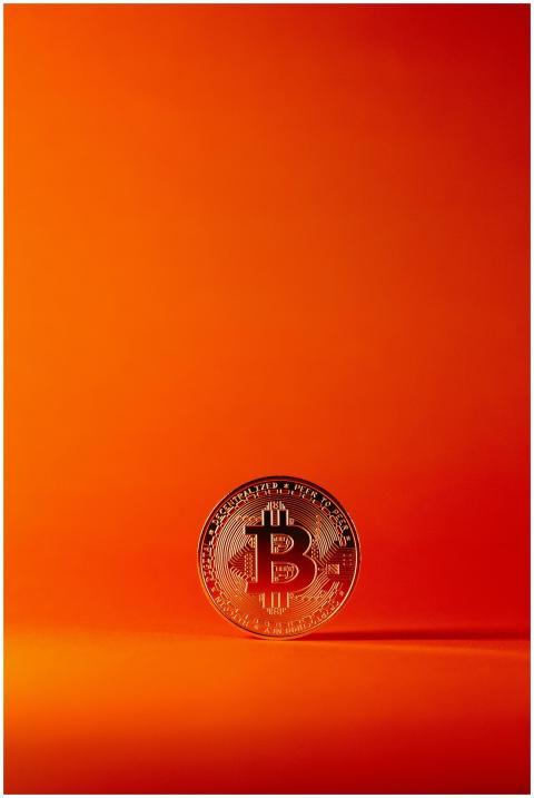 Close-up of a silver Bitcoin coin against a vibran