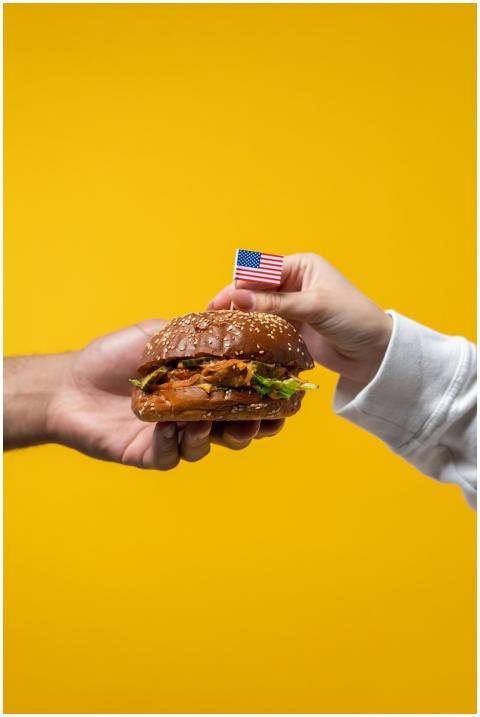 Close-up of a hand holding a delicious hamburger w