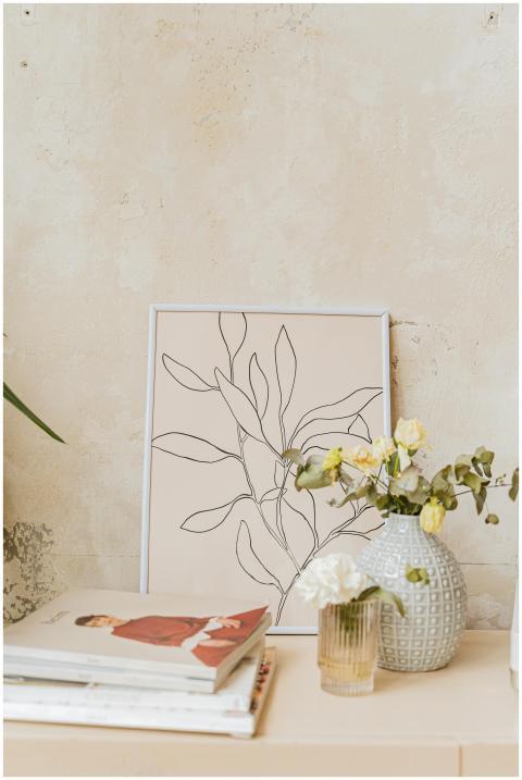 A minimalist interior featuring art and a floral v