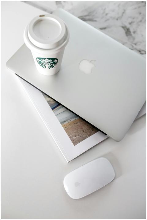 Clean desk setup featuring a laptop, coffee cup, a
