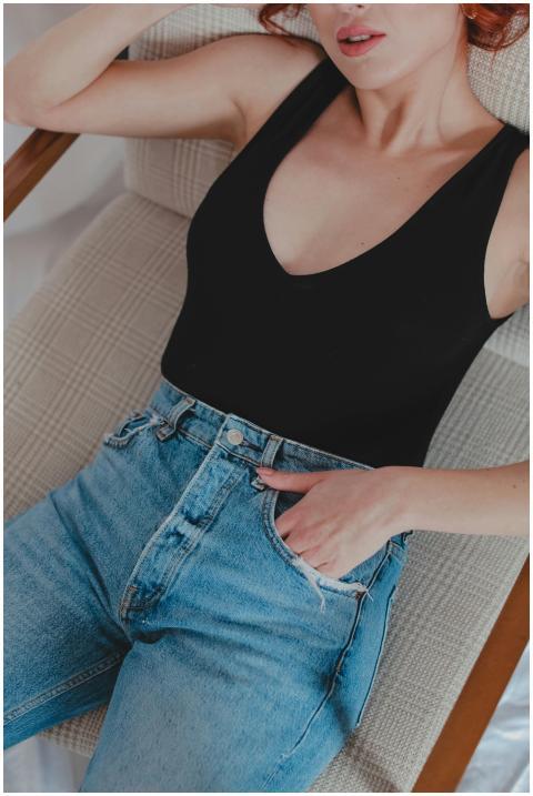 Fashionable woman in denim jeans and black top lou