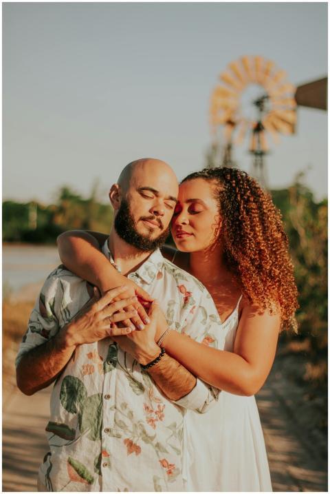 A couple embracing outdoors during a warm sunset i