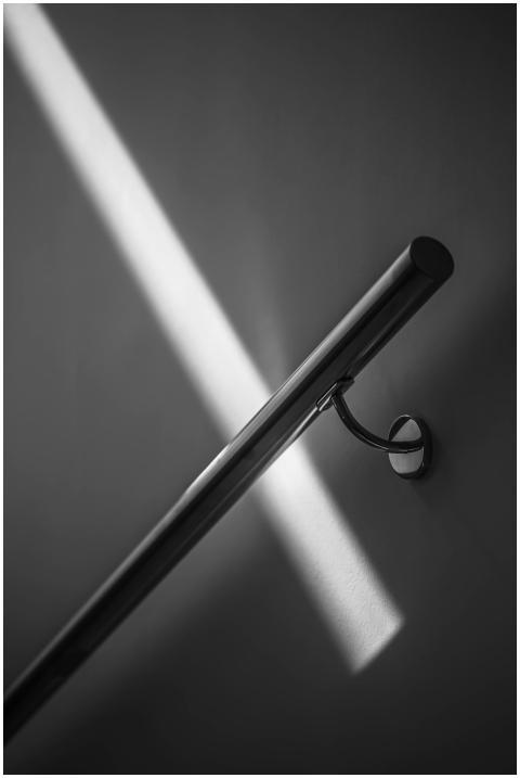 Stainless steel handrail casting shadows in a mini