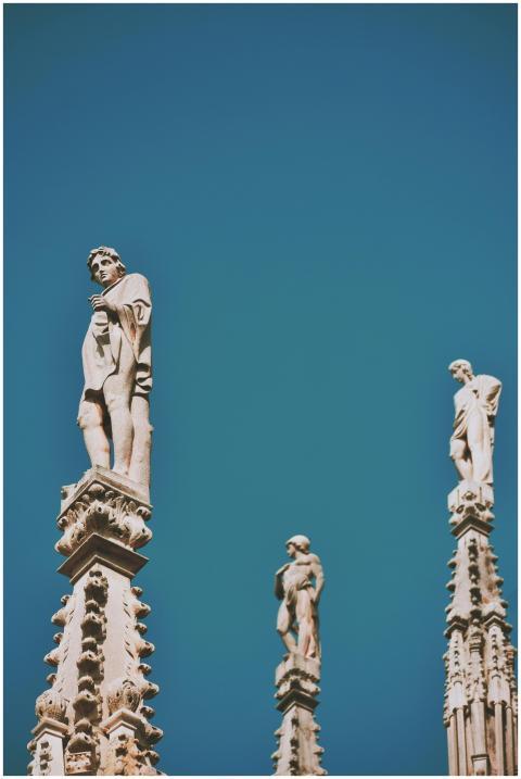 Statues atop architectural columns set against a v