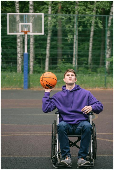 Young man in wheelchair playing basketball on an o
