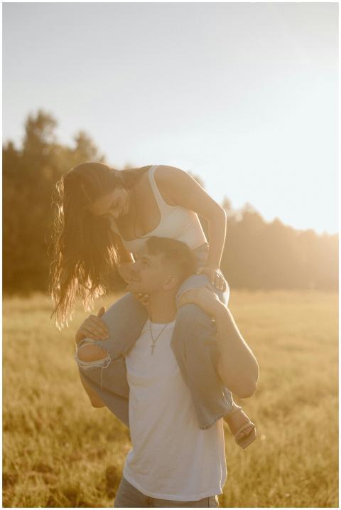 A couple playing outdoors with a woman on a man's