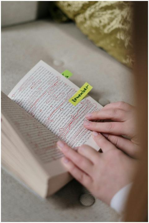 Close-up of hands flipping a book page with highli
