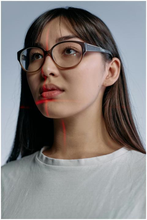 Close-up of a woman wearing glasses with red laser